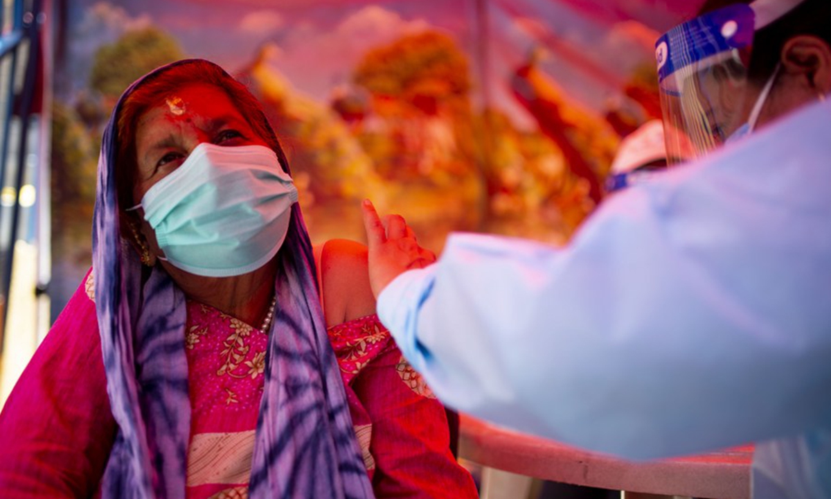 Пожилые непальцы делают уколы после возобновления вакцинации против COVID-19